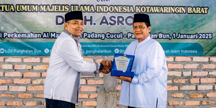 Ketua DPD LDII Kobar Syamsul Arifin saat menyerahkan plakat kepada Ketua Umum Dewan Pimpinan MUI Kobar H. Asroqi. Foto: LINES