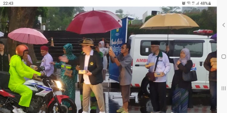Hujan deras yang mengguyur kawasan Gedung Sate dan Gasibu, Bandung, tak menghalangi semangat pengurus DPW LDII Jawa Barat untuk membagikan takjil gratis. Foto: LINES.